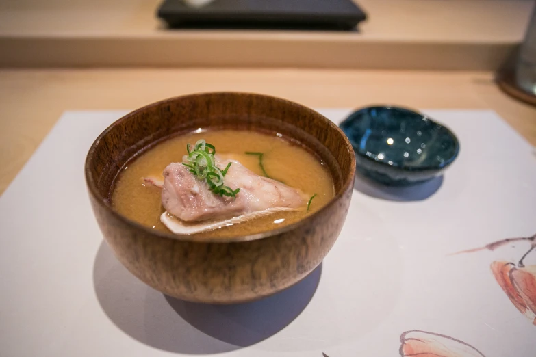 a bowl filled with a variety of soups and a spoon