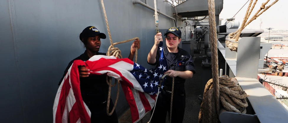 two people on a ship holding american flags