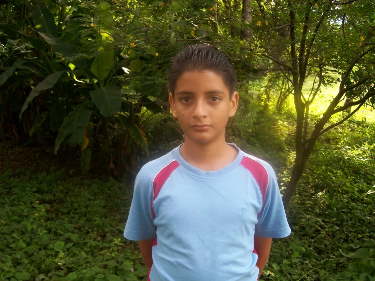 a young man is standing in a park