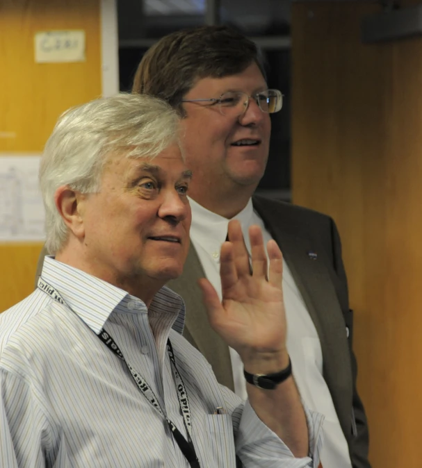 two men standing next to each other talking