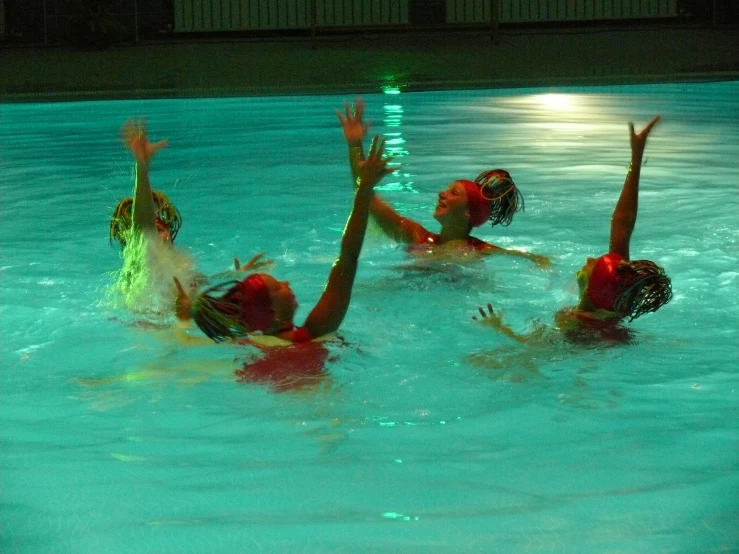 three people that are in the water playing volleyball