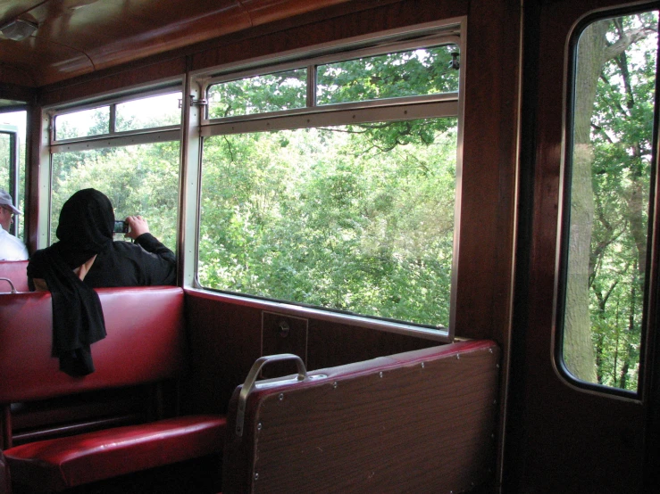 two people sit on a train looking out the windows