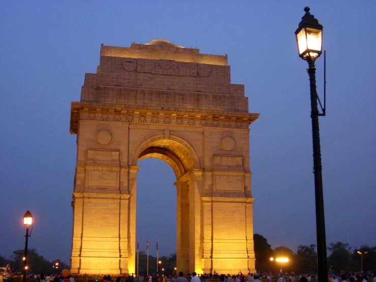 people gathered near a lamp post and archway