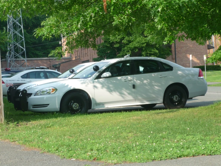 a police car parked next to other cars on a road