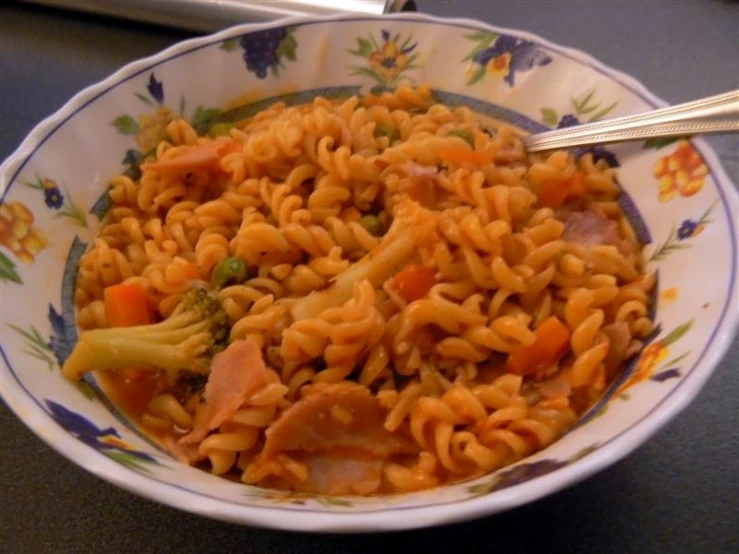 a pasta dish with broccoli, ham and carrots