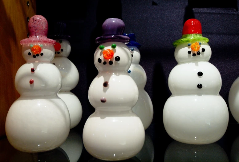 four frosty plastic snowmen with hats on top of them