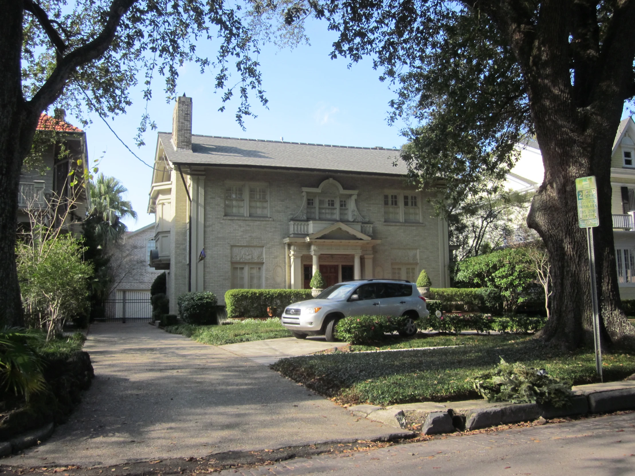 a white house on a quiet street surrounded by trees