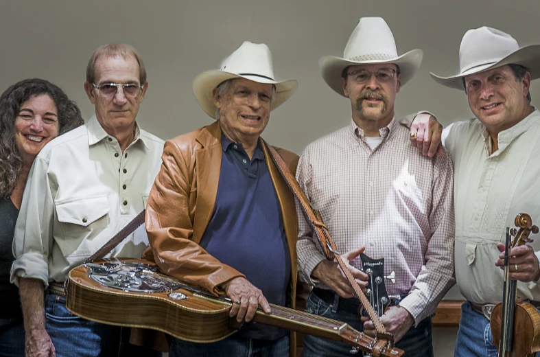 group of people wearing cowboy hats and holding instruments