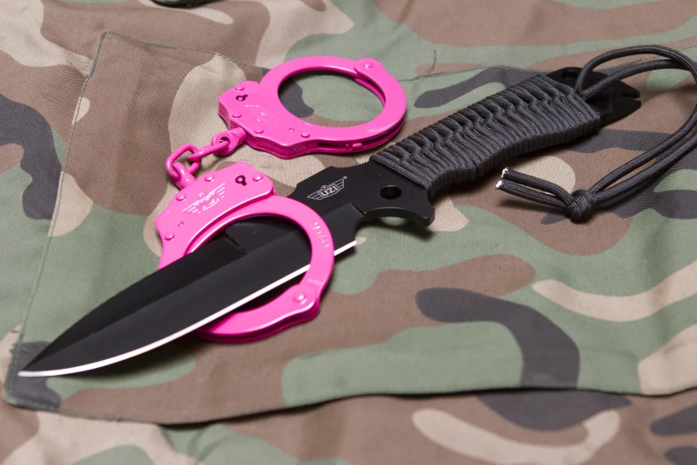 a pink scissor sitting on a camouflage sheet
