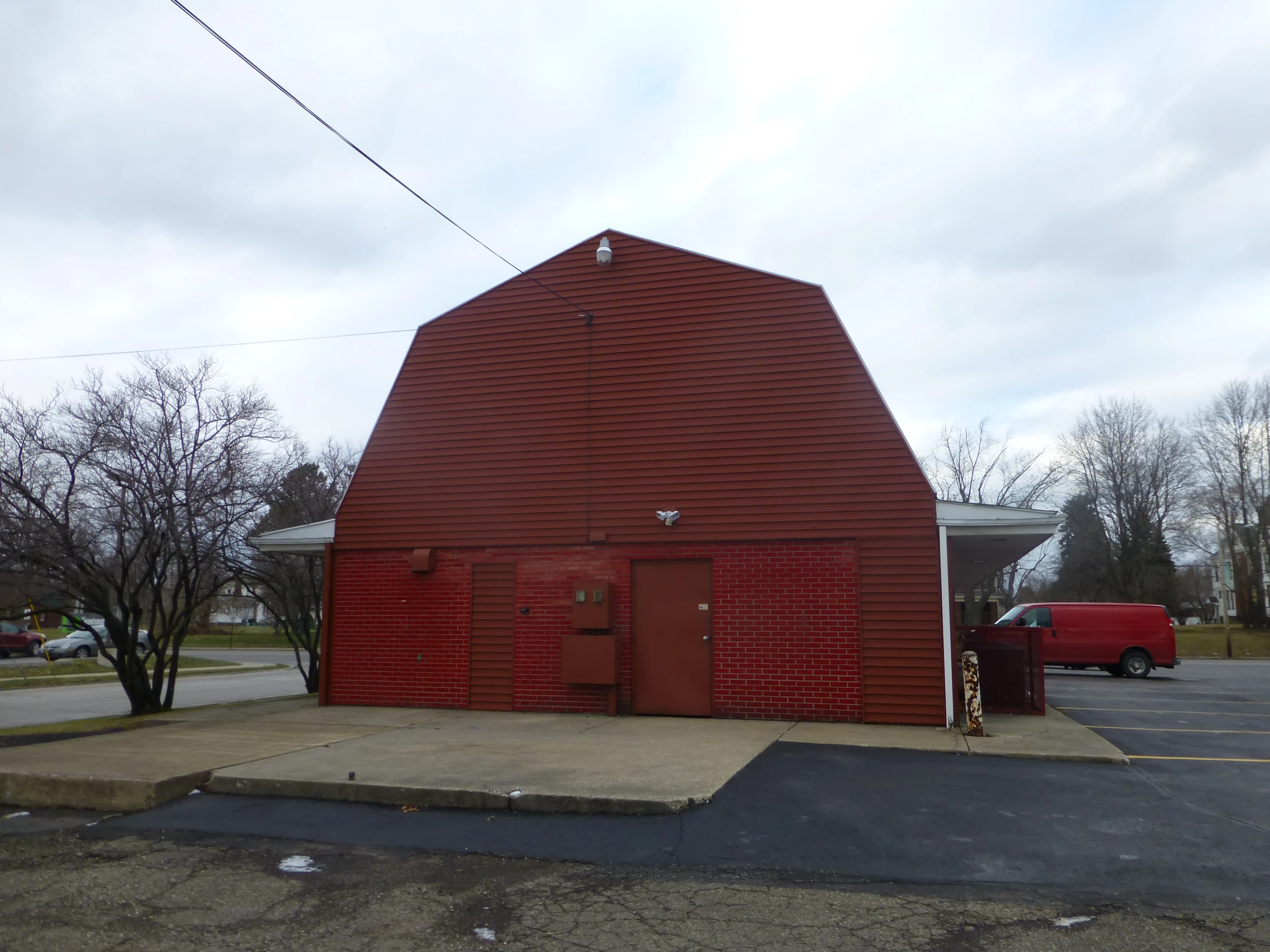 an empty parking lot with two red barns