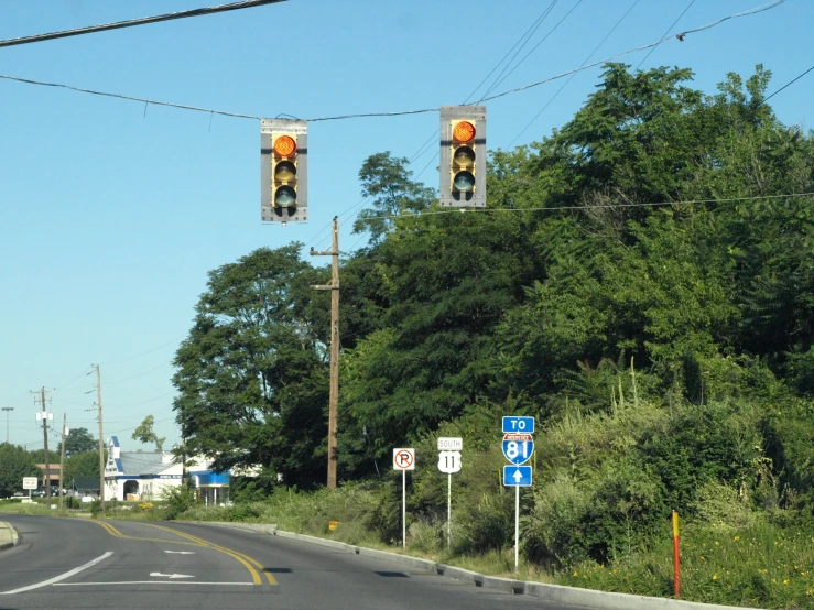 two traffic lights are at the top of a hill