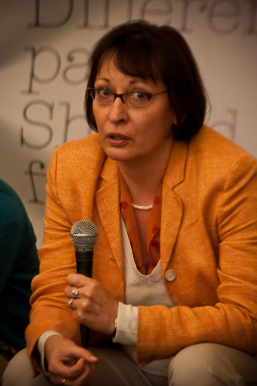 a lady is holding a microphone while standing up