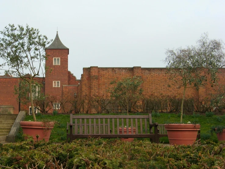 there is a bench near plants in front of a building