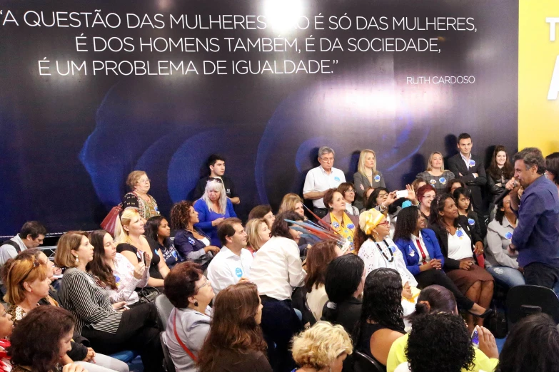 a group of people sitting in front of a black wall