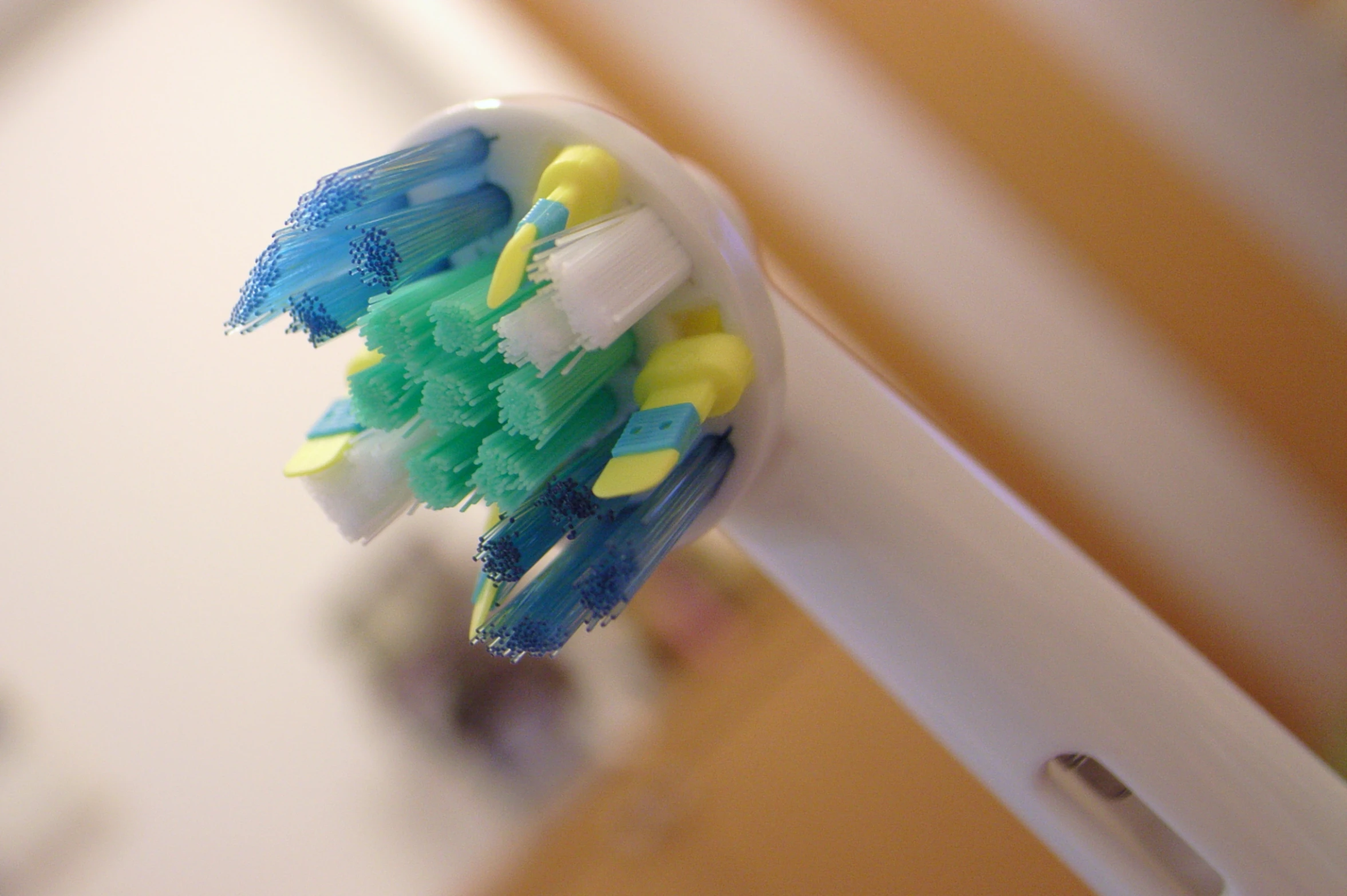 a tooth brush filled with yellow, blue and green toothpaste