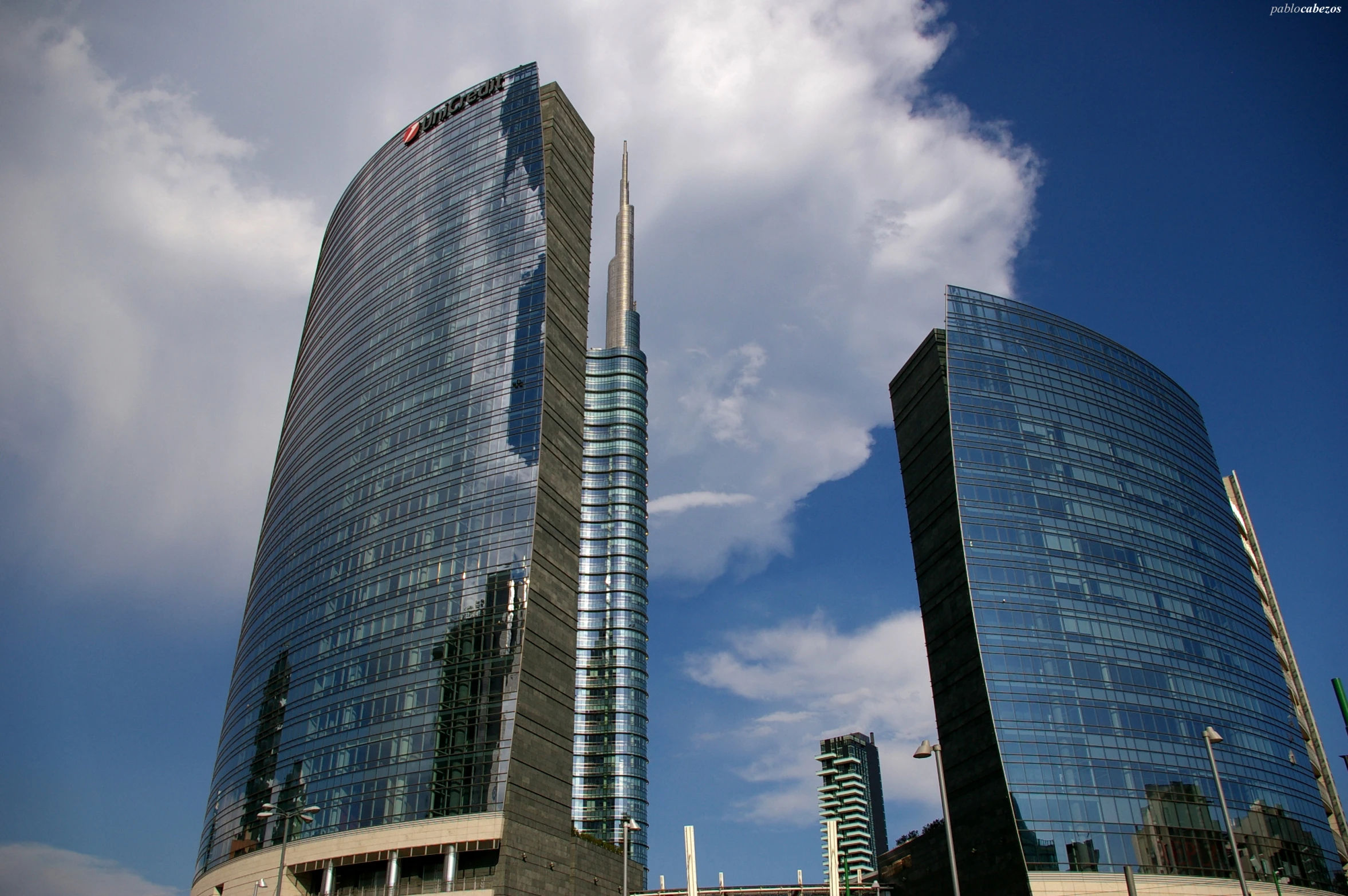 two skyscrs sitting next to each other on a cloudy day