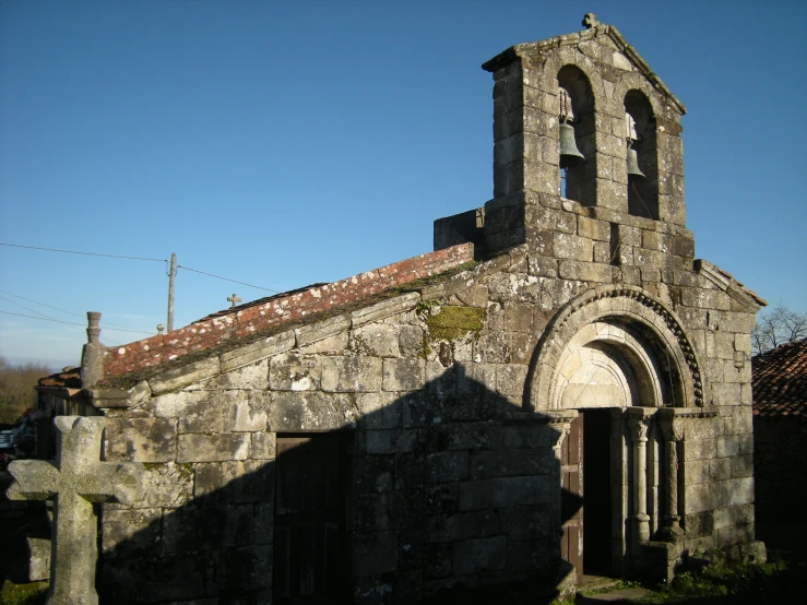 the building is made from gray stone and has an arched window