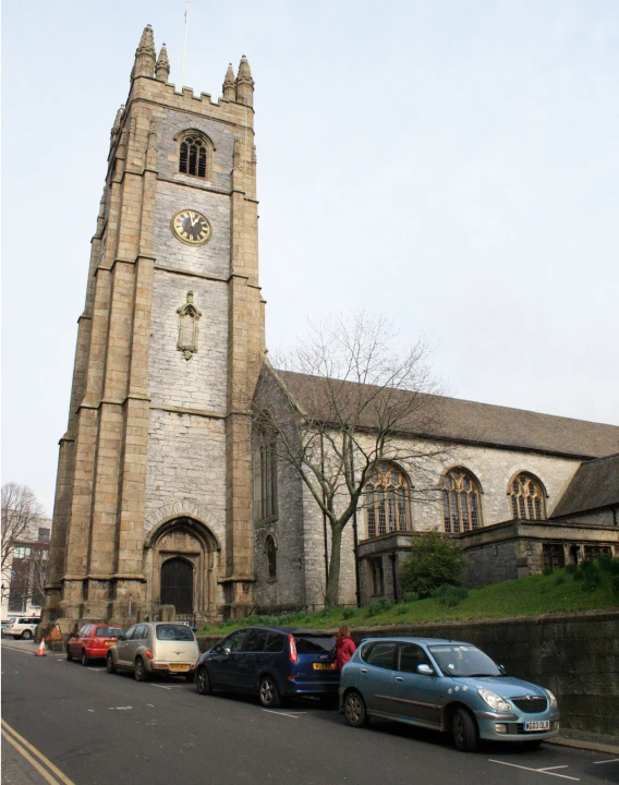 some cars are parked in front of a large church