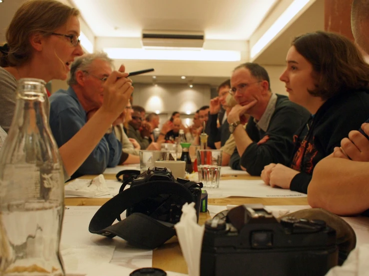 a group of people sitting at a long table