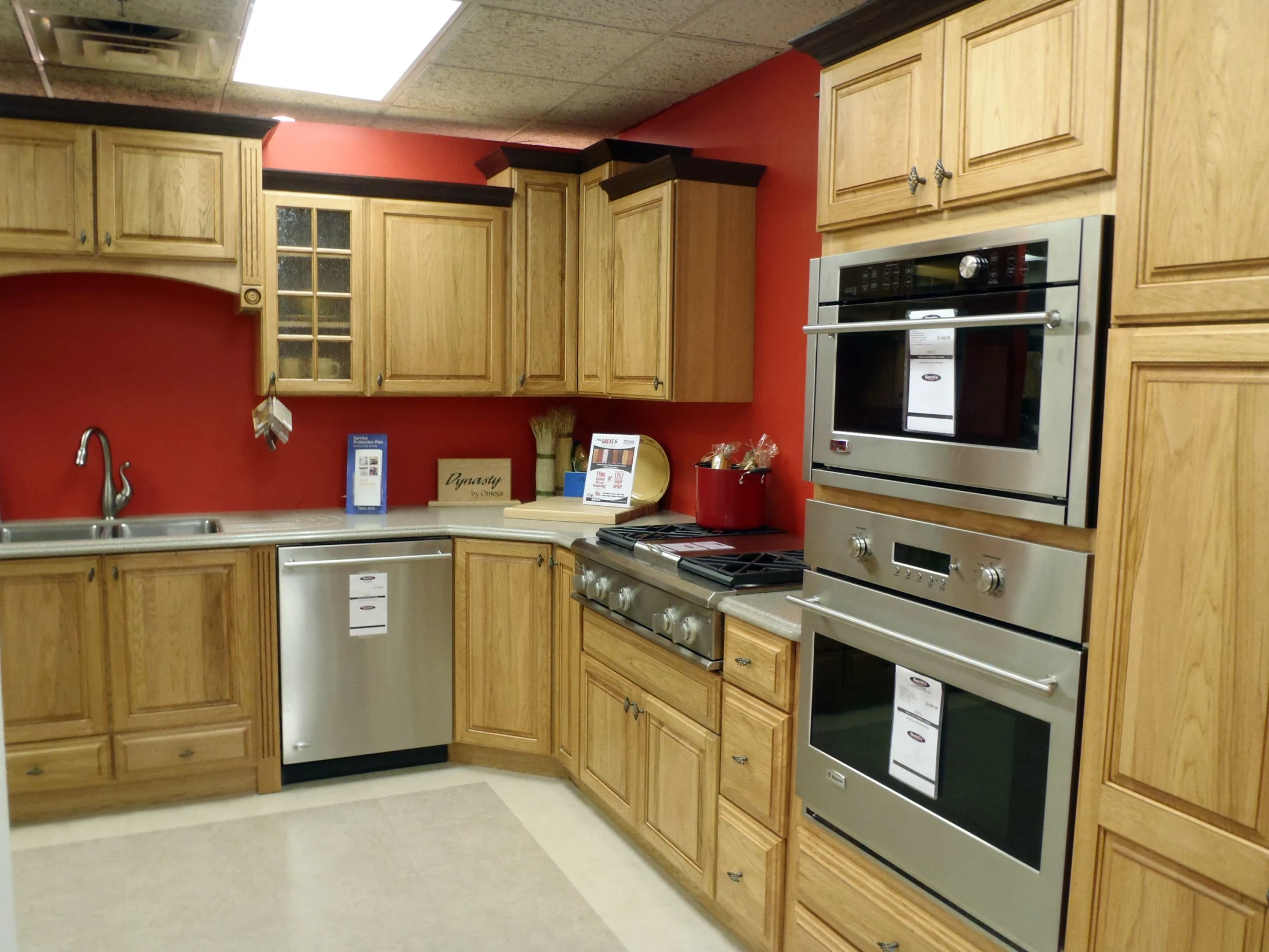 an empty kitchen has stainless steel appliances and wooden cabinets