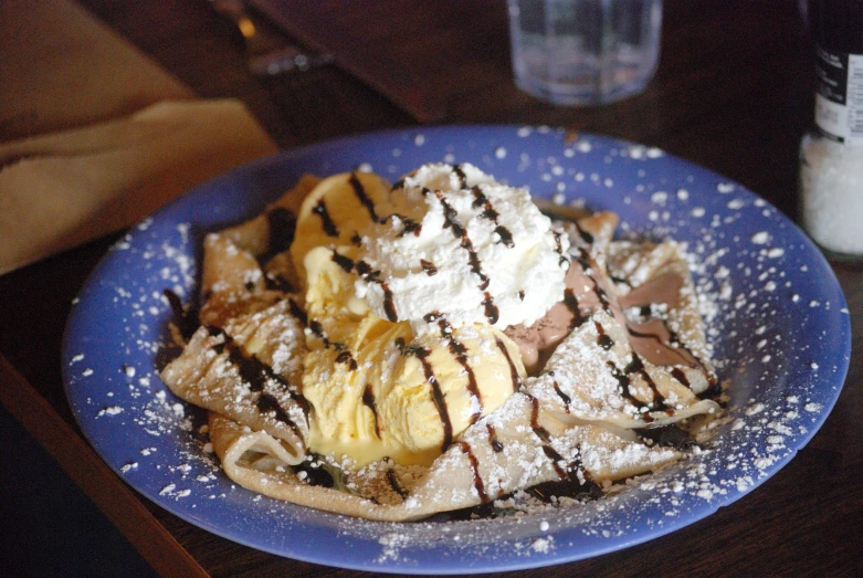 a plate with a waffle topped with bananas and whipped cream