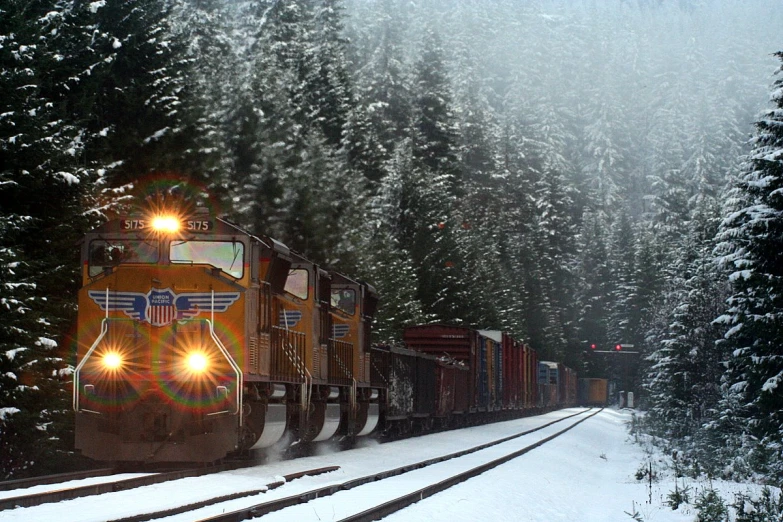 the freight train is going down the snowy tracks