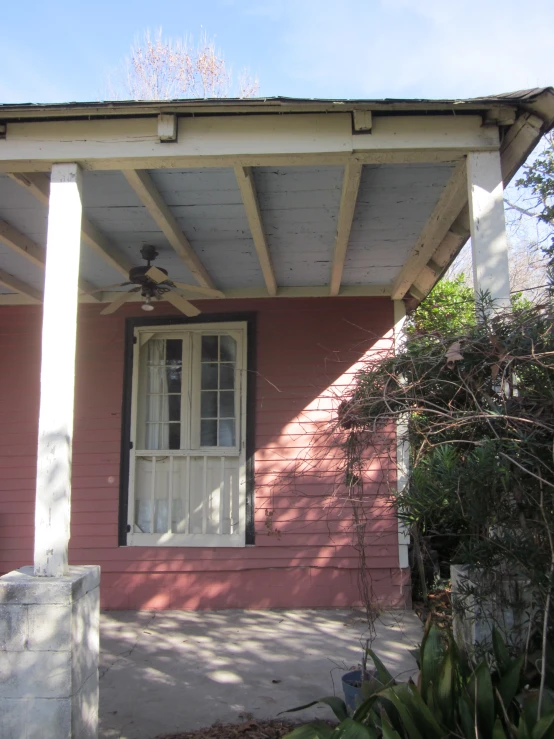 the front porch has a small table and a fan