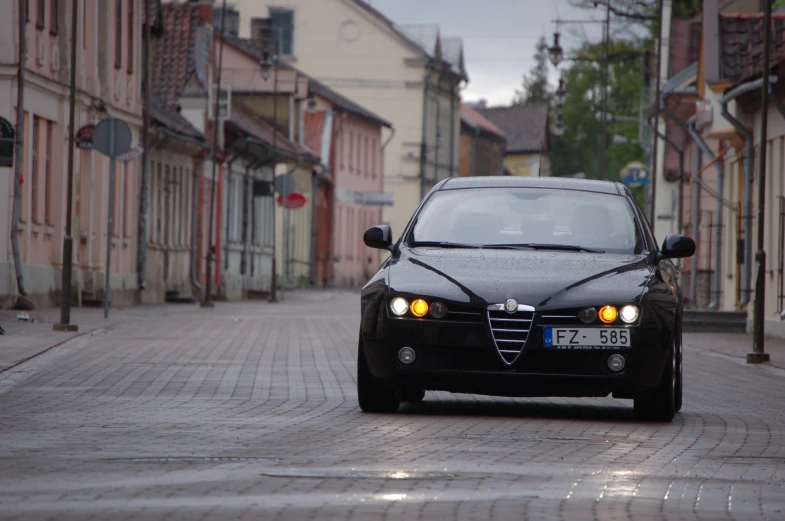 an old style black car is parked on the street