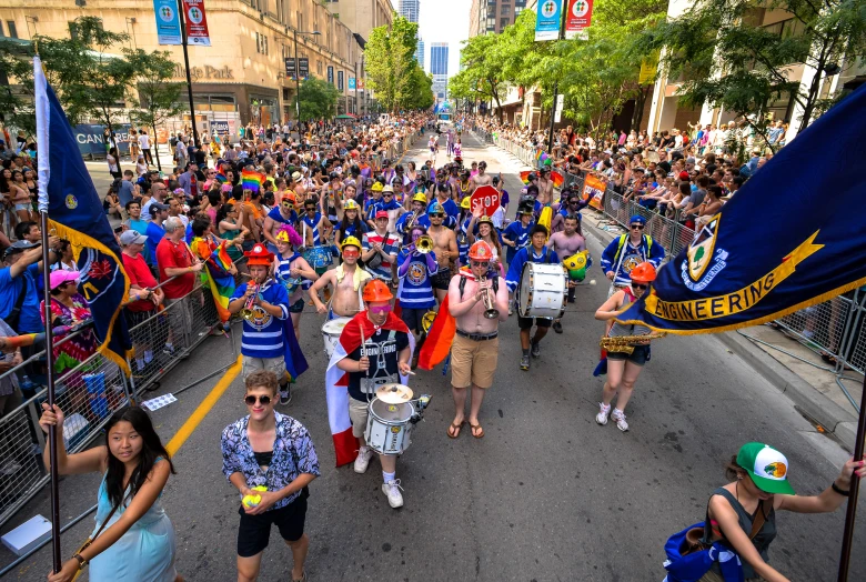 many people are walking in a parade down the street