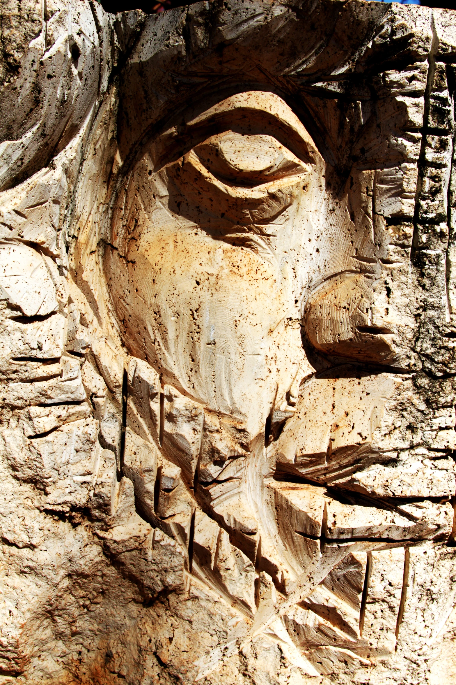 carved relief of a face on a piece of wood