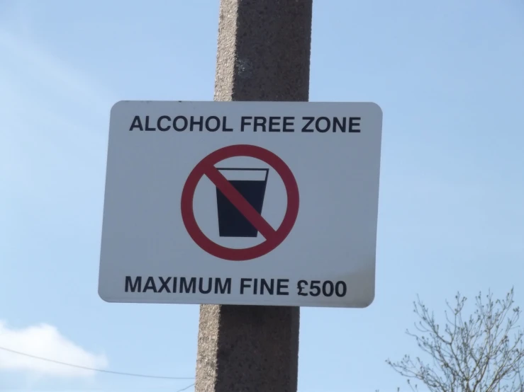 a no drink sign is posted on a street pole