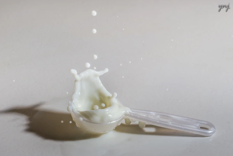 a spoon with milk being poured into it