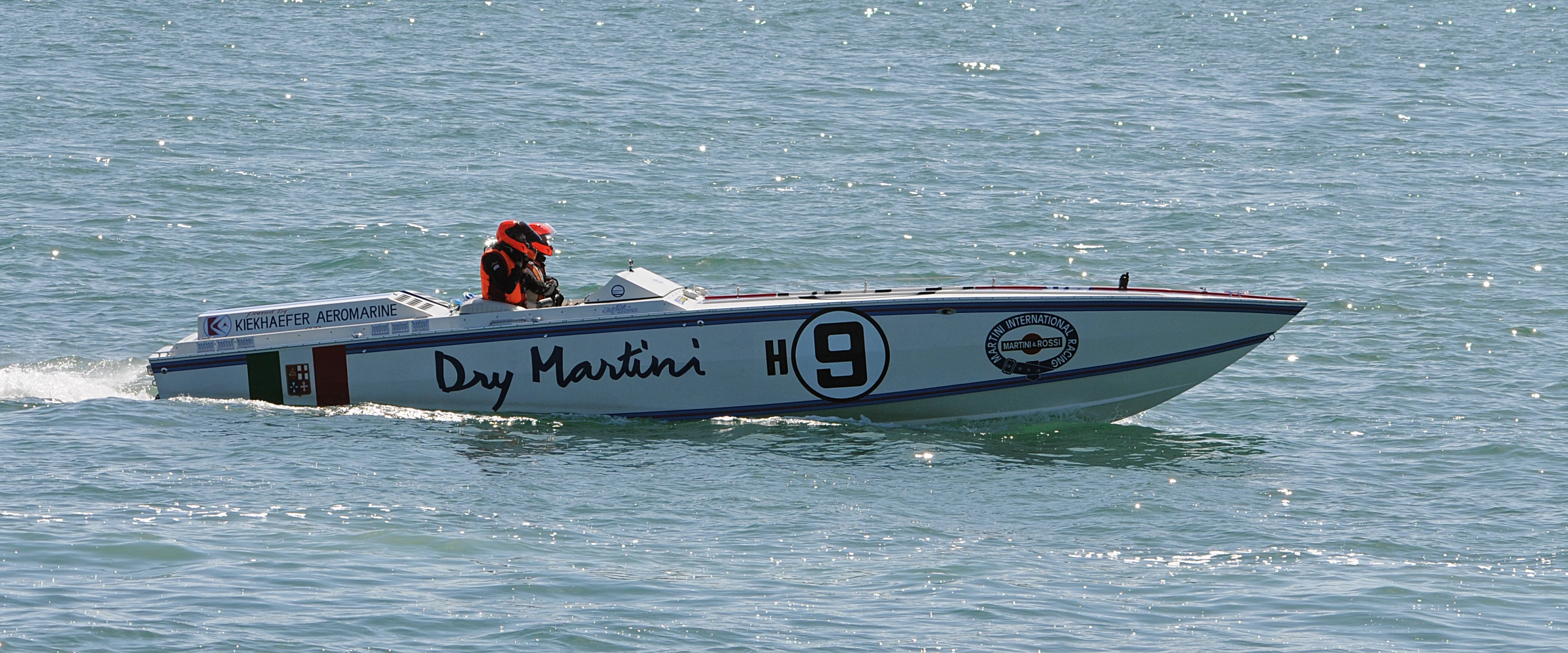 the man is standing on top of his speed boat