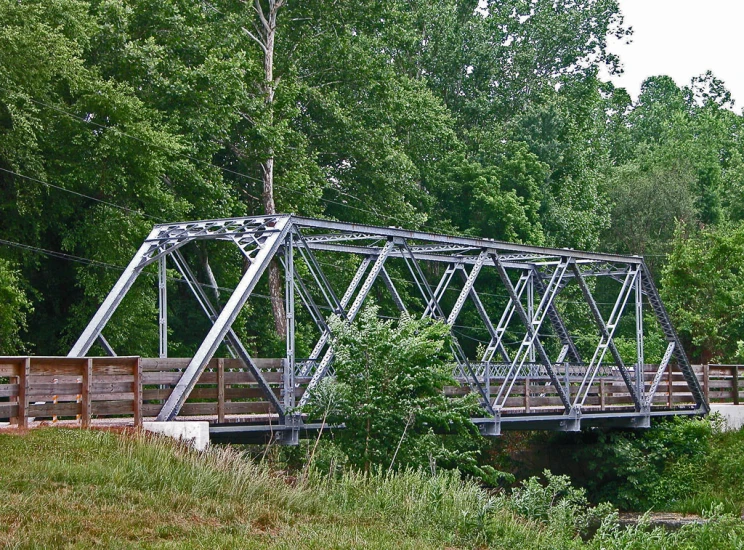 the railroad bridge is in a rural setting