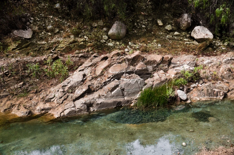 the rocks are rocky and clear with water below them