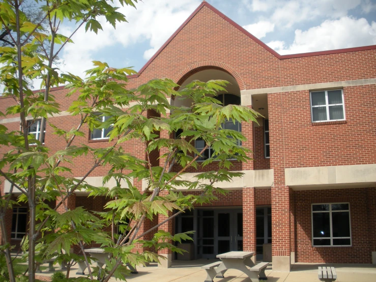 an outside view of a building with tables and benches