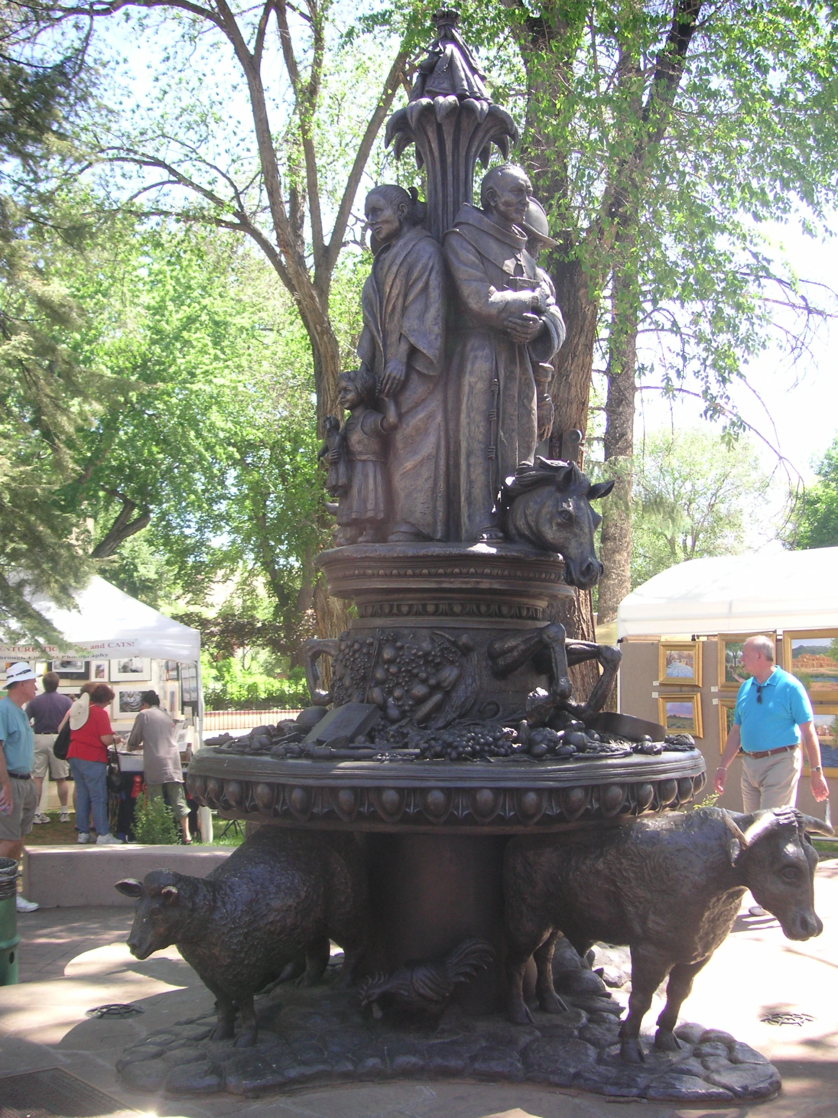 a fountain with some animals and a statue on it