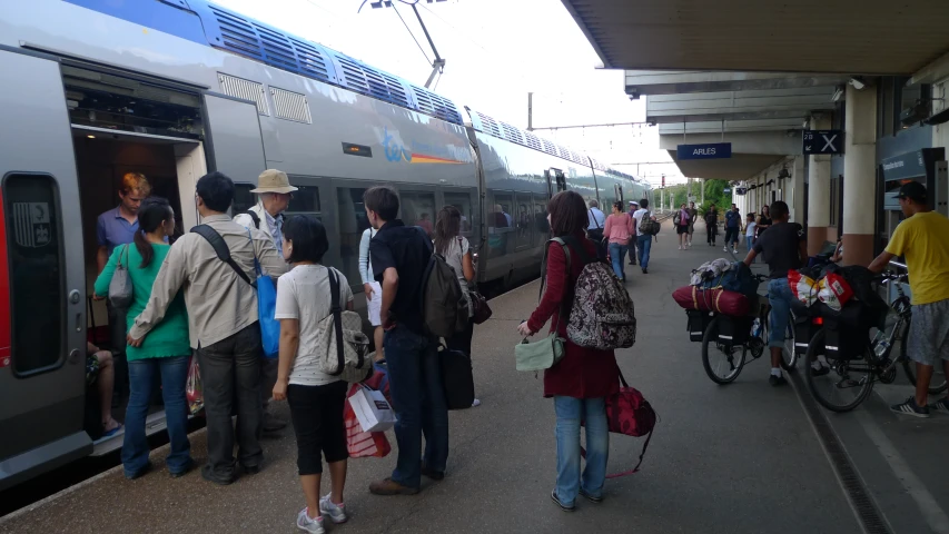 people getting on and off the train at the station