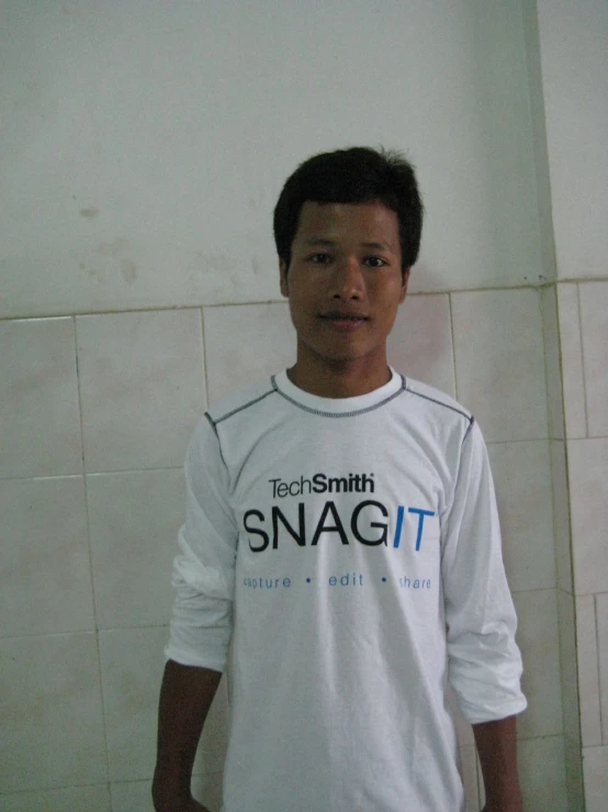 a man wearing a white shirt and standing on tile