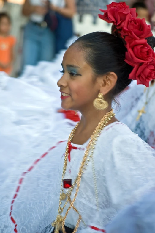 a woman wearing a white outfit and big golden earrings