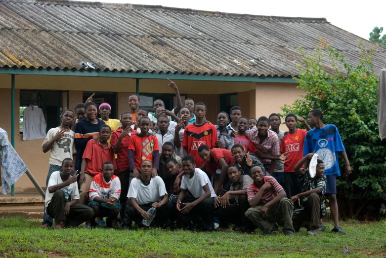 group of children posing for a pograph in front of their houses