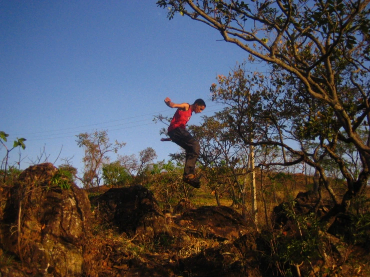 a person jumping on top of a cliff