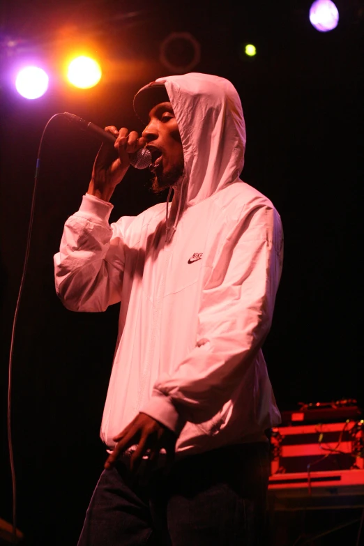 a man with a white coat holding a microphone in front of him