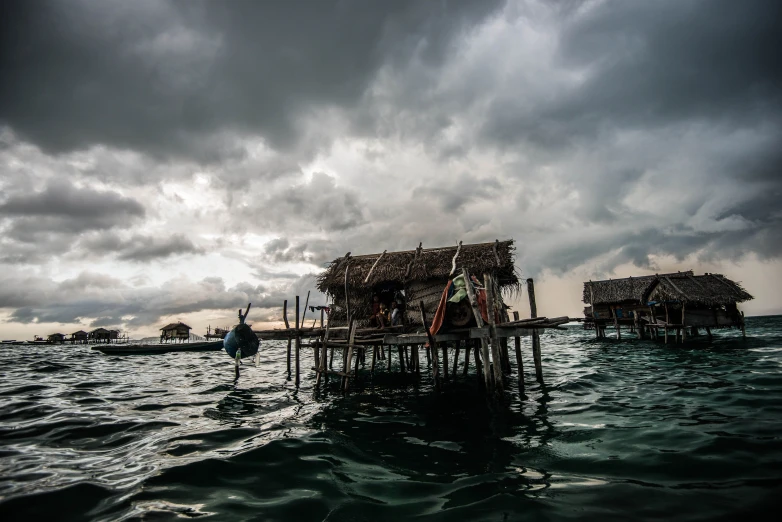 the water with boats parked in the harbor and some wooden poles