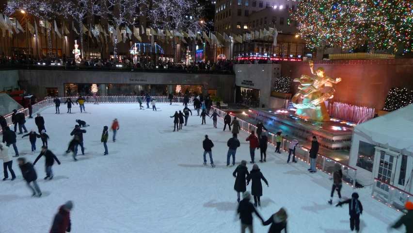 a bunch of people skating down the ice rink