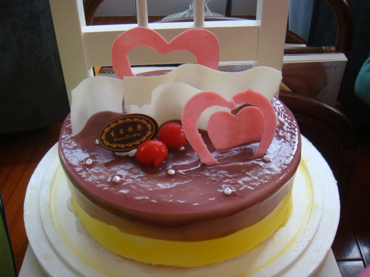 a three layered cake with two heart shaped decorations