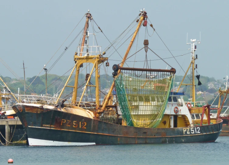 large fishing boat docked in the water near many other boats