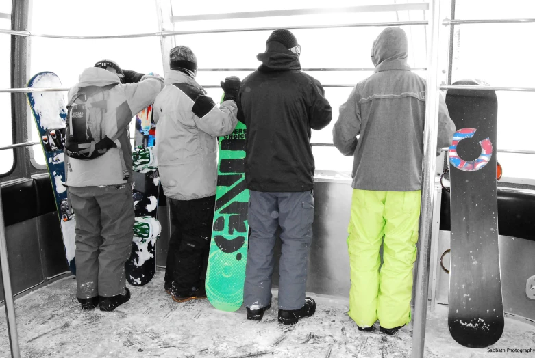 three snowboarders standing around each other next to their board