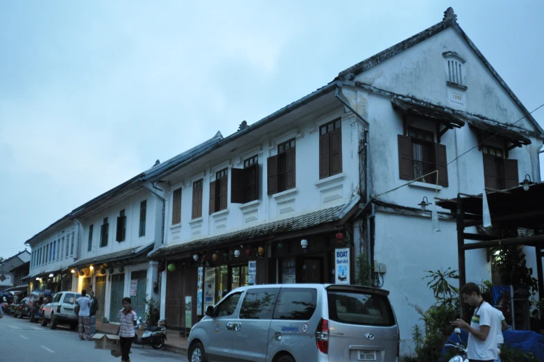 an old building with many windows and people walking by