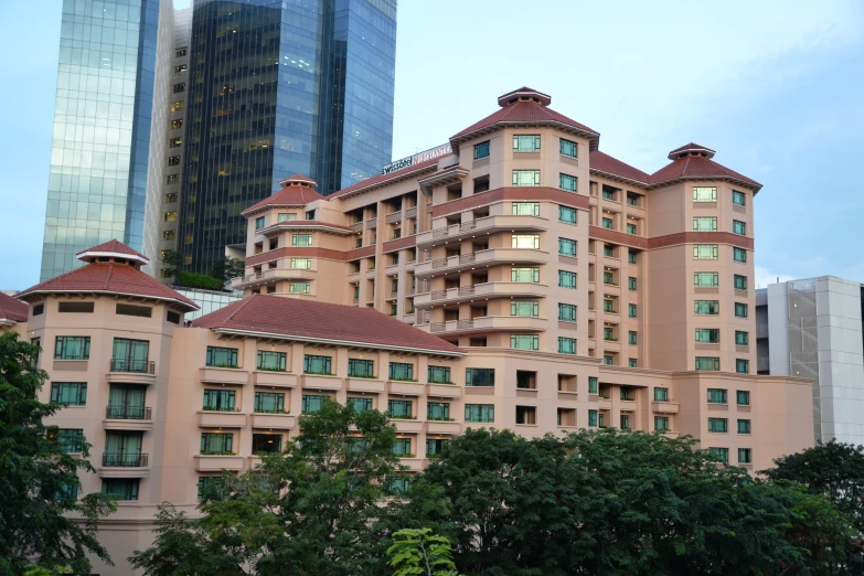 an old pink building in the city with trees and buildings behind it